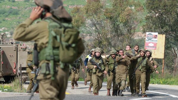 Israeli soldiers carry a wounded comrade on a stretcher near Israel's border with Lebanon - Sputnik Mundo