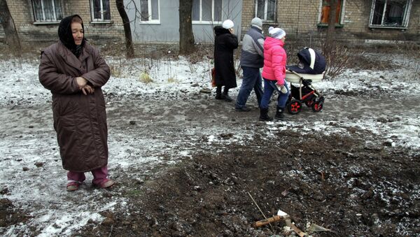 A woman looks at a crater left in the ground after shelling in Makiivka, Donetsk region, on January 27, 2015 - Sputnik Mundo