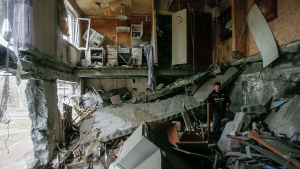 A man stands in a flat at a residential block damaged by a recent shelling in Yenakieve town, northeast from Donetsk, February 2, 2015 - Sputnik Mundo