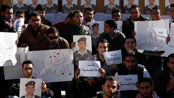 Students hold pictures of Islamic State captive Jordanian pilot Muath al-Kasaesbeh - Sputnik Mundo
