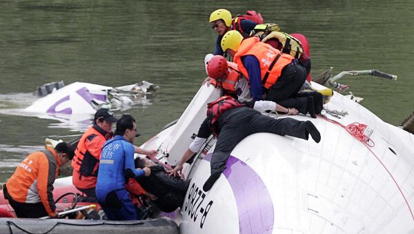 Rescuers pull a passenger out of the TransAsia Airways plane which crash landed in a river, in New Taipei City, February 4, 2015 - Sputnik Mundo