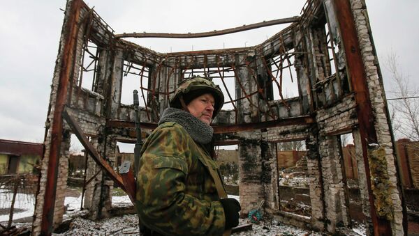 A member of the armed forces of the separatist self-proclaimed Donetsk People's Republic looks on near a building destroyed during battles with the Ukrainian armed forces in Vuhlehirsk, Donetsk region, February 4, 2015 - Sputnik Mundo