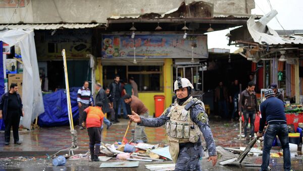 A member of the Iraqi security forces walks past the site of a bomb attack in Baghdad February 7, 2015. - Sputnik Mundo