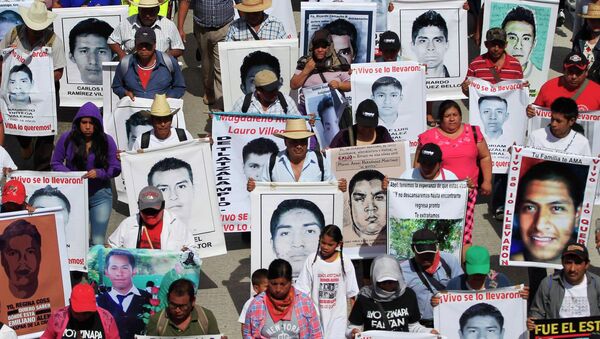 Familiares sostienen retratos de los 43 estudiantes desaparesidos en Guerrero, México - Sputnik Mundo