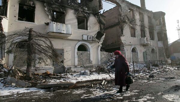 A woman walks past a damaged building in the town of Vuhlehirsk near Donetsk, Ukraine, February 14, 2015 - Sputnik Mundo