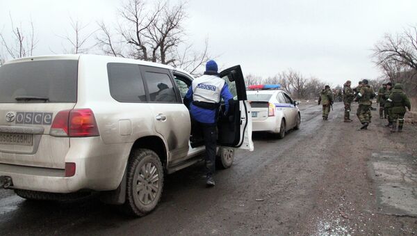 Автомобили ОБСЕ и полиции, которые сопровождают колонну автобусов, прибывших в Дебальцево - Sputnik Mundo