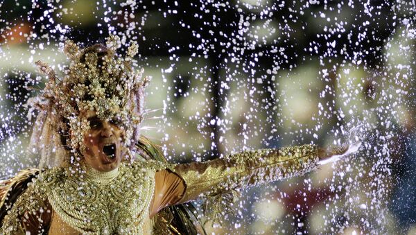 Rain water splashes up onto a performer on the float of the Viradouro samba school, during the Carnival parade at the Sambadrome in Rio de Janeiro, Brazil, Sunday, Feb. 15, 2015 - Sputnik Mundo