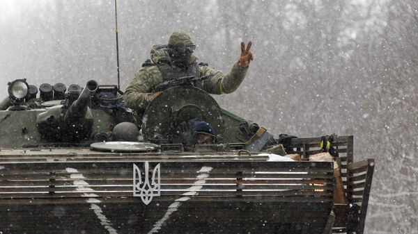 An Ukrainian soldier strikes a V-Victory sign driving on his vehicle on the road between the towns of Debaltseve and Artemivsk, Ukraine, Monday, Feb. 16, 2015. - Sputnik Mundo