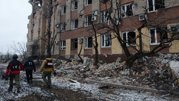 Журналисты у разрушенного в результате обстрела здания аэропорта города Донецка. - Sputnik Mundo