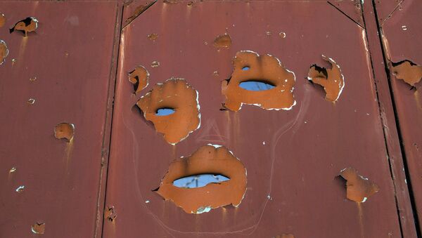 A gate filled with shrapnel holes is pictured in Donetsk's Oktyabrski district - Sputnik Mundo