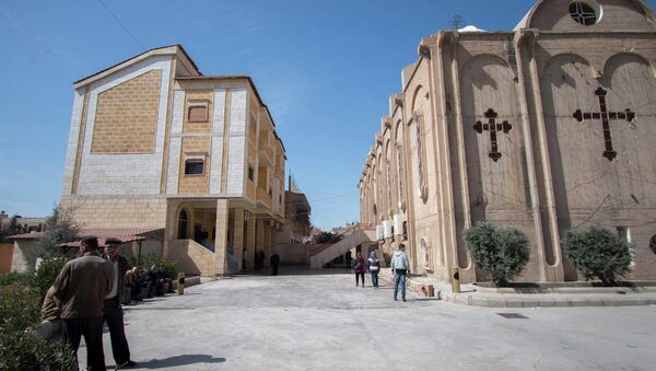 Displaced Assyrians, who fled from the villages around Tel Tamr, sit outside the Assyrian Church in al-Hasaka city, as they wait for news about the Assyrians abductees remaining in Islamic State hands March 9, 2015. - Sputnik Mundo