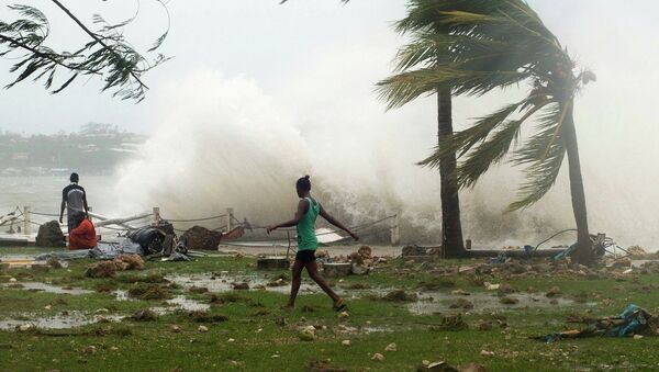 Local residents walk past debris as a wave breaks nearby in Port Vila, the capital city of the Pacific island nation of Vanuatu March 14, 2015. - Sputnik Mundo