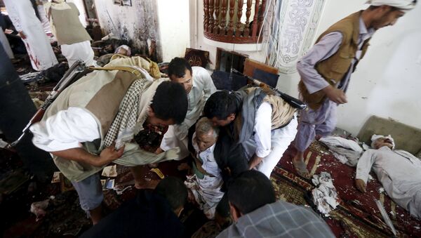 People help an injured man at the scene of a suicide bombing inside a mosque in Sanaa March 20, 2015 - Sputnik Mundo