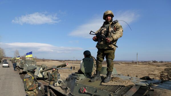 A Ukrainian serviceman stands atop an armored vehicle with canons on a road in the village of Fedorivka, eastern Ukraine, Friday, Feb. 27, 2015 - Sputnik Mundo