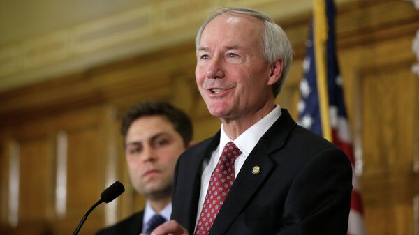 Arkansas Gov. Asa Hutchinson answers reporters' questions as Sen. Jonathan Dismang, R-Beebe, background, listens at the state Capitol in Little Rock, Ark., Wednesday, April 1, 2015 - Sputnik Mundo