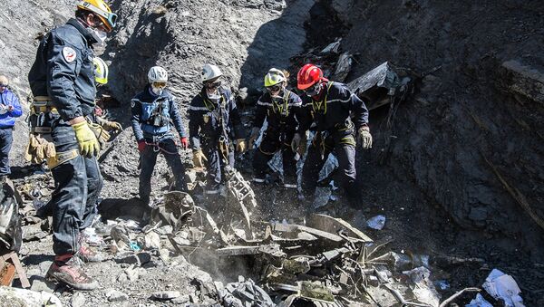 Resuce workers and investigators, seen in this picture made available to the media by the French Interior Ministry April 1, 2015, work near debris from wreckage at the crash site of a Germanwings Airbus A320, near Seyne-les-Alpes - Sputnik Mundo