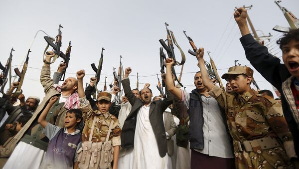 Seguidores del movimiento hutíes levantan sus rifles mientras gritan eslóganes contra los ataques aéreos saudíes en Saná - Sputnik Mundo