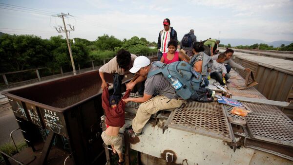 Central American migrants board a northbound freight train in Ixtepec, Mexico - Sputnik Mundo