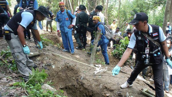 Policías cerca de una de las fosas descubiertas en Tailandia - Sputnik Mundo