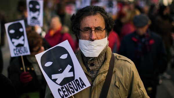 Un hombre sostiene un cartel de censura - Sputnik Mundo