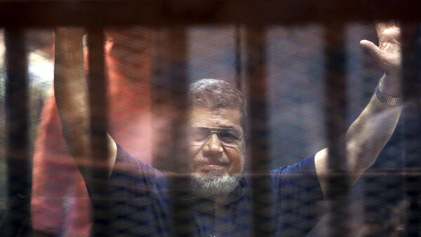 Former Egyptian President Mohamed Mursi waves as he enters for his trial with other Muslim Brotherhood members at a court in the outskirts of Cairo, May 16, 2015 - Sputnik Mundo