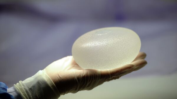 A picture taken on January 12, 2012 in Boissy-l'Aillerie, northern Paris, shows a technician presenting a silicone breast implant - Sputnik Mundo