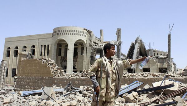 A Houthi militant stands in front of a court building, which was damaged in a Saudi-led air strike in Saada May 31 - Sputnik Mundo