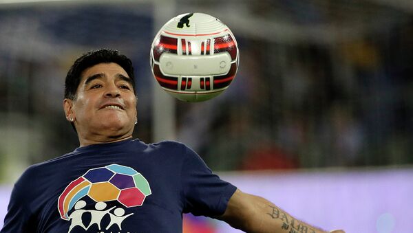 Argentine soccer legend Diego Armando Maradona watches the ball as he warms up prior to the start of an inter-religious match for peace, supported by Pope Francis to promote the dialogue and peace among different religions, at Rome's Olympic Stadium, Monday, Sept. 1, 2014.  - Sputnik Mundo