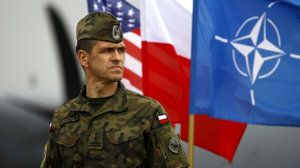Soldado polaco al lado de las banderas nacionales de los EEUU y Polonia y la bandera de la OTAN - Sputnik Mundo