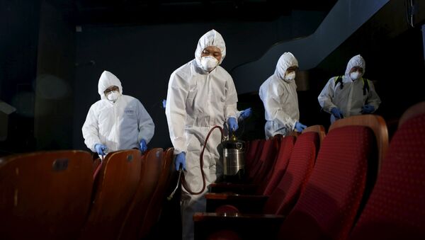 Empleados de un servicio de desinfección en un teatro de Seúl - Sputnik Mundo