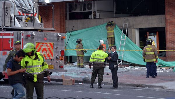 Colombian police officers and firefighters check the site of an explosion in the financial heart of Bogota - Sputnik Mundo
