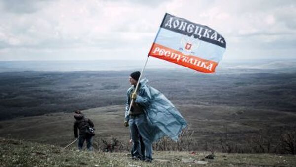 Hombre con la bandera de la RPD cerca el monumento de Saur Moguila en Donetsk, Ucrania - Sputnik Mundo