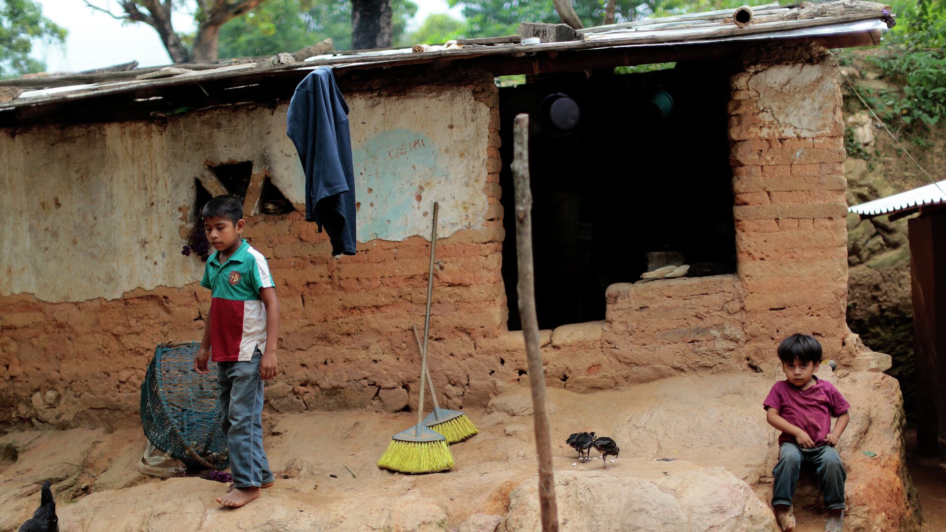 Niños permanecen frente a su humilde hogar en El Magueyito, estado de Guerrero, México, el 19 de julio de 2015 - Sputnik Mundo, 1920, 08.12.2021