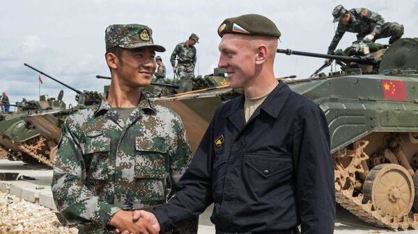 Soldado chino y soldado ruso se dan un apretón de manos durante Juegos Militares de Rusia - Sputnik Mundo