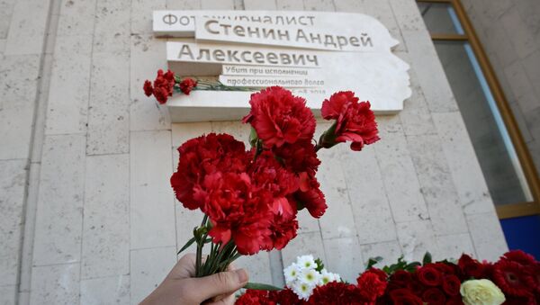 Flores en la placa conmemorativa en honor al periodista Andréi Stenin - Sputnik Mundo