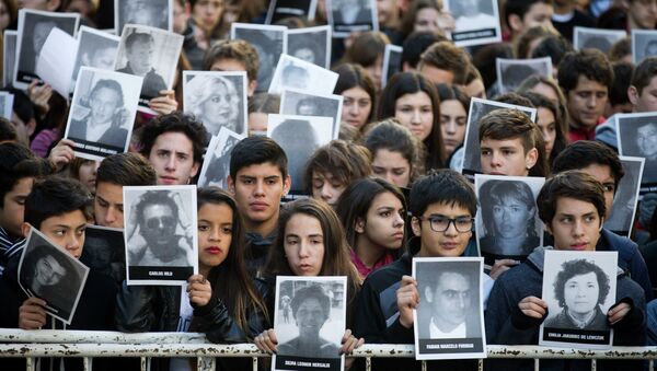 People hold pictures of the victims of the 1994 bombing of the AMIA Jewish community center on the 21st anniversary of the terror attack in Buenos Aires, Argentina - Sputnik Mundo