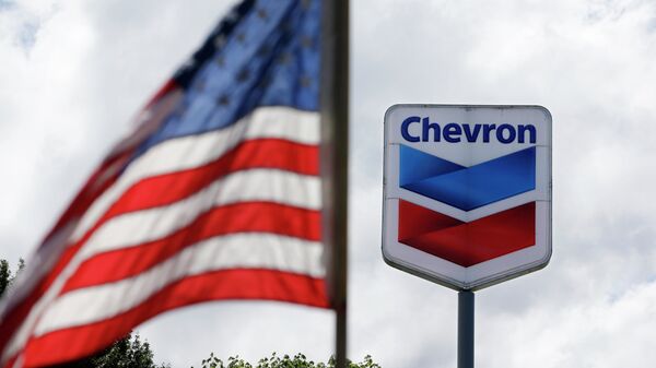 Bandera de EEUU y el logotipo de la petrolera Chevron - Sputnik Mundo