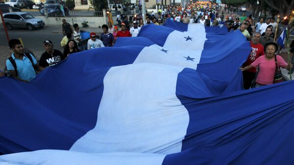 Manifestantes con la bandera de Honduras - Sputnik Mundo