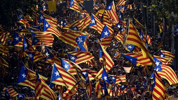 A file picture taken on September 11, 2014 shows demonstrators waving Estelada flags (Catalan independentist flags) during celebrations of the Diada (Catalonia National Day) in Barcelona.  - Sputnik Mundo