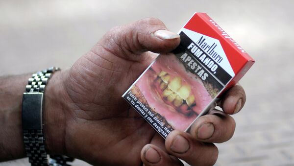 Cajetilla de cigarrillos con una advertencia Fumando, apestas - Sputnik Mundo