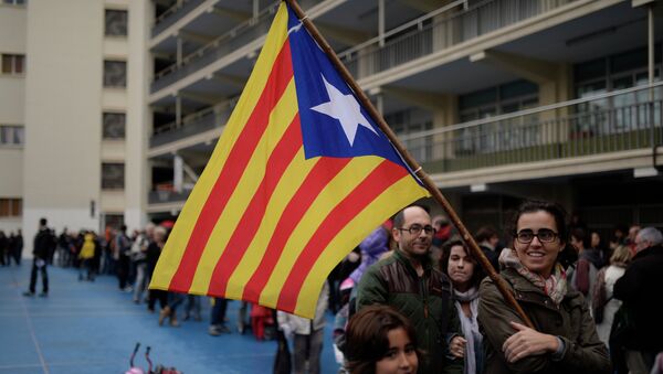 People queue with the Estelada flag (pro-independence Catalan flag) to cast their vote at a polling station for an informal poll for the independence of Catalonia in Barcelona, Spain - Sputnik Mundo