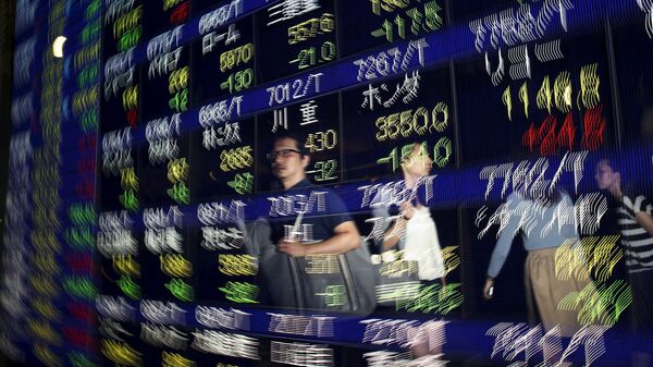 Passersby are reflected on a display showing stock quotation board outside a brokerage in Tokyo August 25, 2015. - Sputnik Mundo