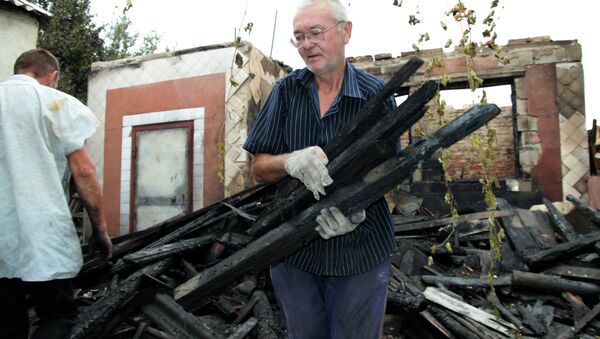 Hombre cerca de su casa destruida en la región de Donetsk - Sputnik Mundo