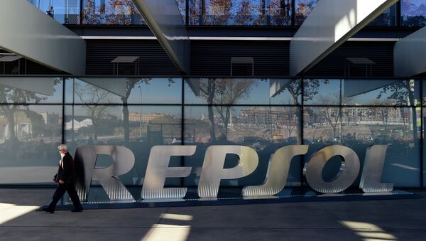 A woman walks past the headquarters of Spanish oil company Repsol in Madrid on December 16, 2014 - Sputnik Mundo