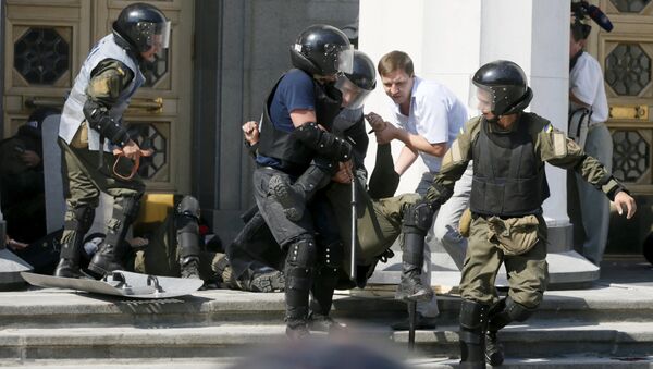 Militares ucranianos llevan un herido durante enfrentamientos junto a la sede del Parlamento ucraniano - Sputnik Mundo