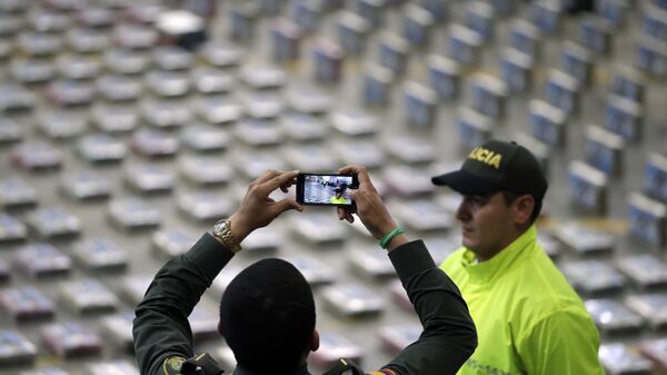 Policía toma fotos de paquetes de cocaína presentados por la Policía para la prensa en Bogota, Colombia - Sputnik Mundo