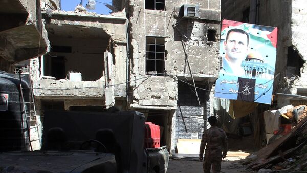 Un retrato del presidente sirio Bashar al-Assad en una calle de la capital siria, Damasco, el 6 de abril de 2015 - Sputnik Mundo