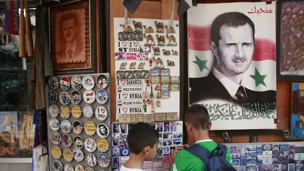 Un retrato del presidente sirio Bashar Asad en Damasco - Sputnik Mundo