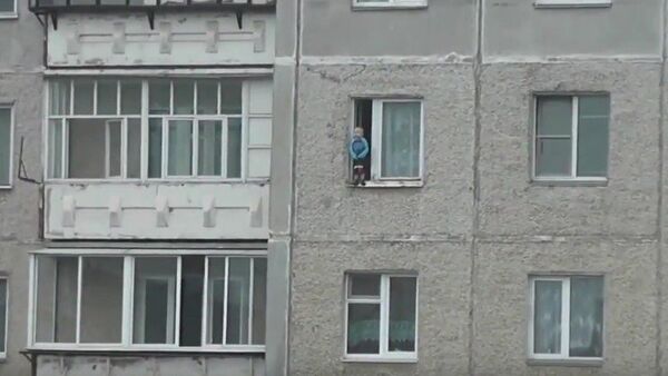 Un niño juega en la cornisa de la ventana en la ciudad de Miass - Sputnik Mundo