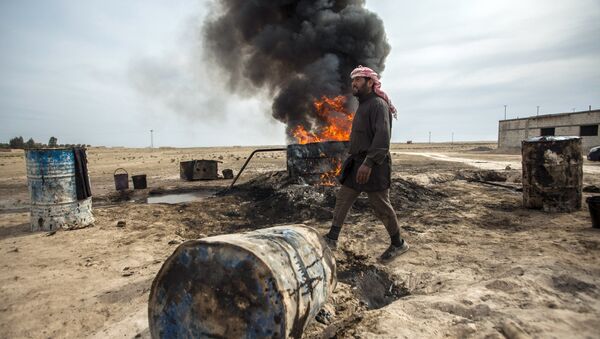 Un hombre trabaja en una refinería de petróleo improvisada en Raqqa - Sputnik Mundo